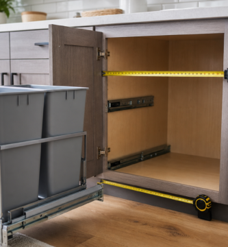 Kitchen cabinet opening with pull-out trash can frame and measuring tape