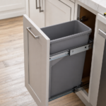 Slim pull-out trash can in a narrow kitchen cabinet with measuring tape