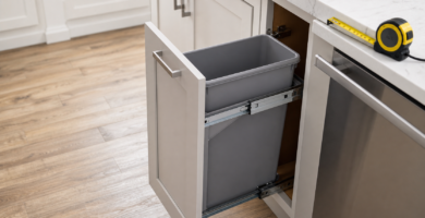 Slim pull-out trash can in a narrow kitchen cabinet with measuring tape