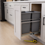 Pull-out trash can system extended from a kitchen cabinet with measuring tape