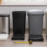 Different household trash can sizes with folded trash bags and a measuring tape