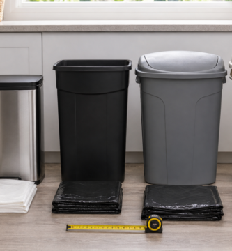 Different household trash can sizes with folded trash bags and a measuring tape
